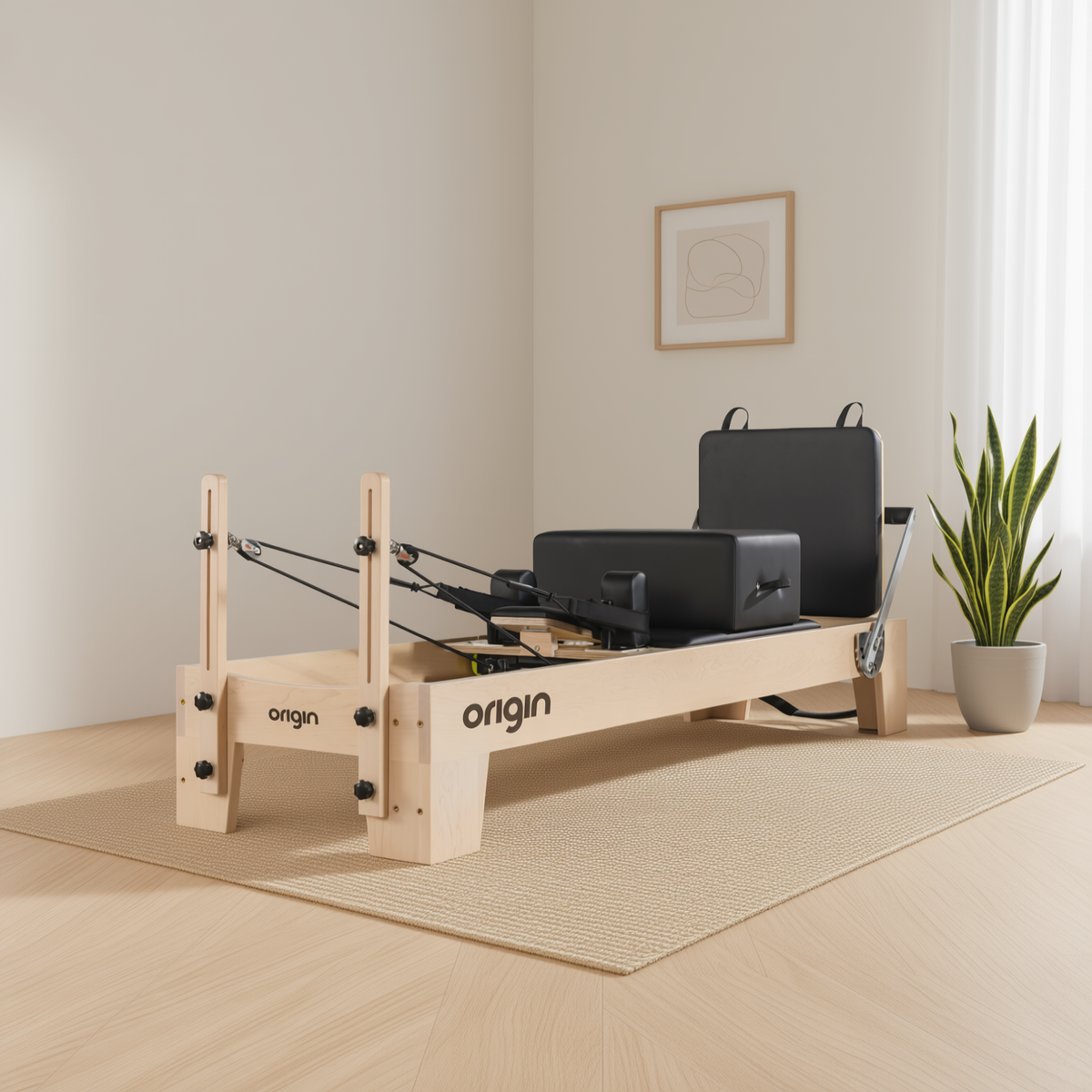 Origin Maple Reformer Pilates machine with a maple frame in a bright studio beside a plant