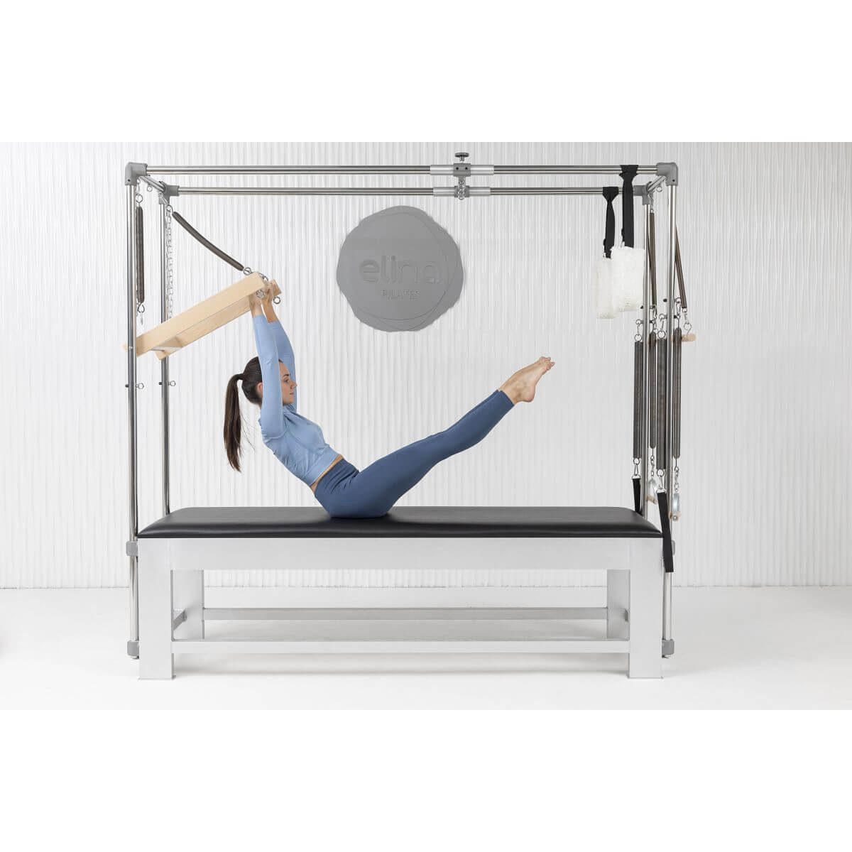 Woman performing a suspended stretch on the Elina Pilates Classic Aluminium Cadillac