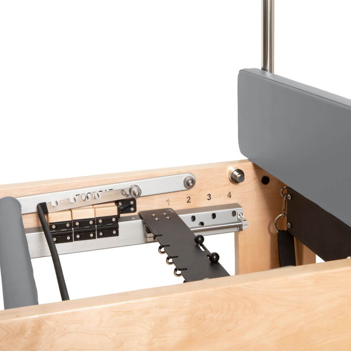 Close-up of the spring adjustment plate and padded backrest on the Elina Pilates Cadillac Reformer