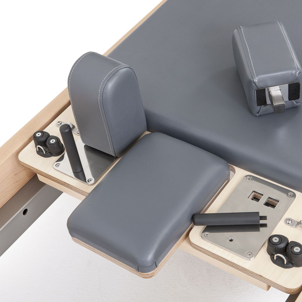 Close-up of the grey shoulder rests and headrest controls on the Elina Pilates Elite Reformer
