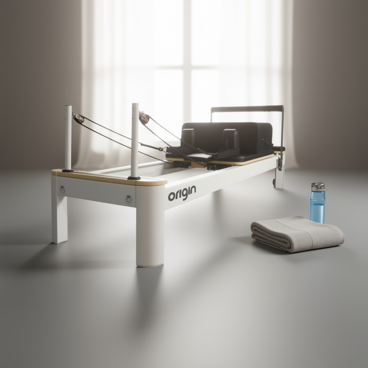 Origin Aluminium Reformer Pilates machine with a white frame, towel and water bottle