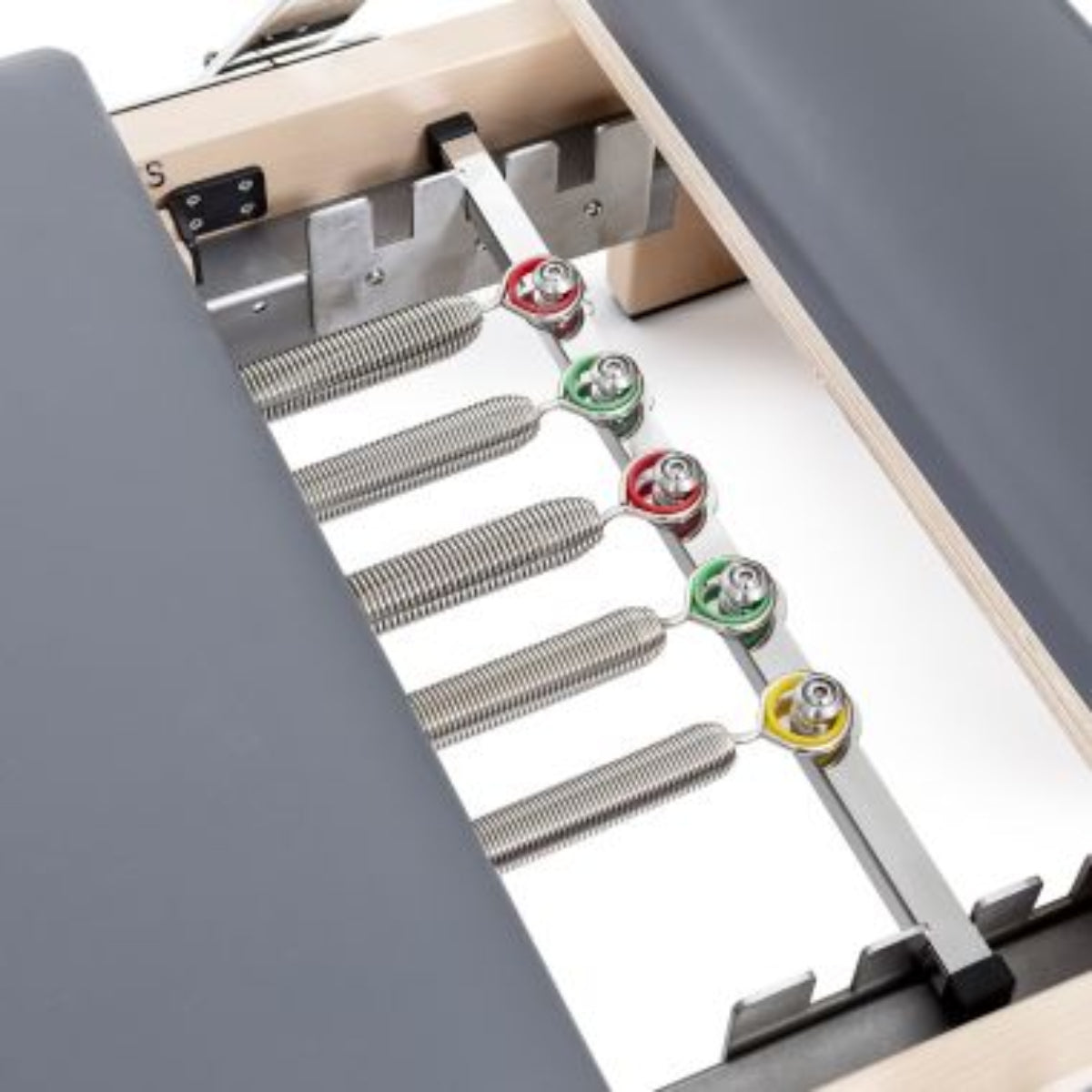 Close-up of the colour-coded spring settings inside the Elina Pilates Lignum Reformer